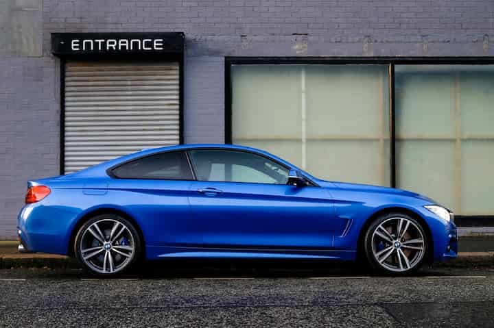 blue-coupe-beside-gray-house-blue-car