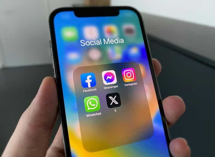 a-person-holding-a-cell-phone-with-social-media-on-the-screen-facebook-instagram-whatsapp