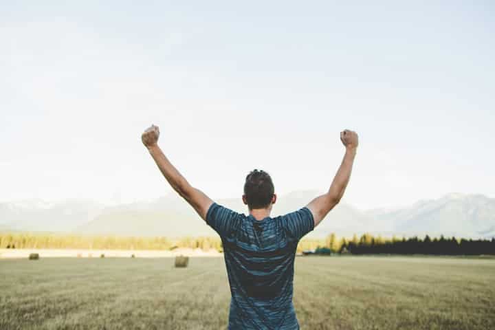 man-reaching-hands-up-high-taken-at-daytime-brave-proud