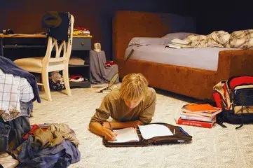 messy room and a boy studing duolingo describe image